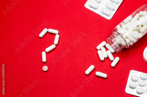 Blue Pills and Pill Bottle in the shape of a Question Mark. © Artur Falgowski