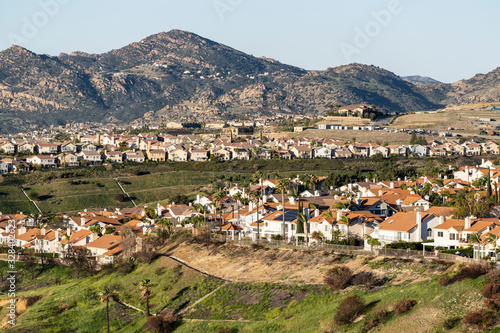 Rows of hilltop houses in northern Los Angeles, California.  Ongoing construction and the Santa Susana Mountains are in the background. photo