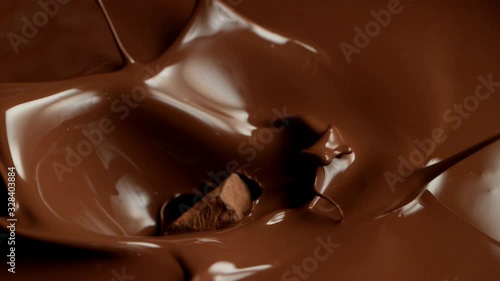 Super slow motion of flying raw chocolate pieces splashing into molten chocolate. Filmed on high speed cinema camera, 1000fps.