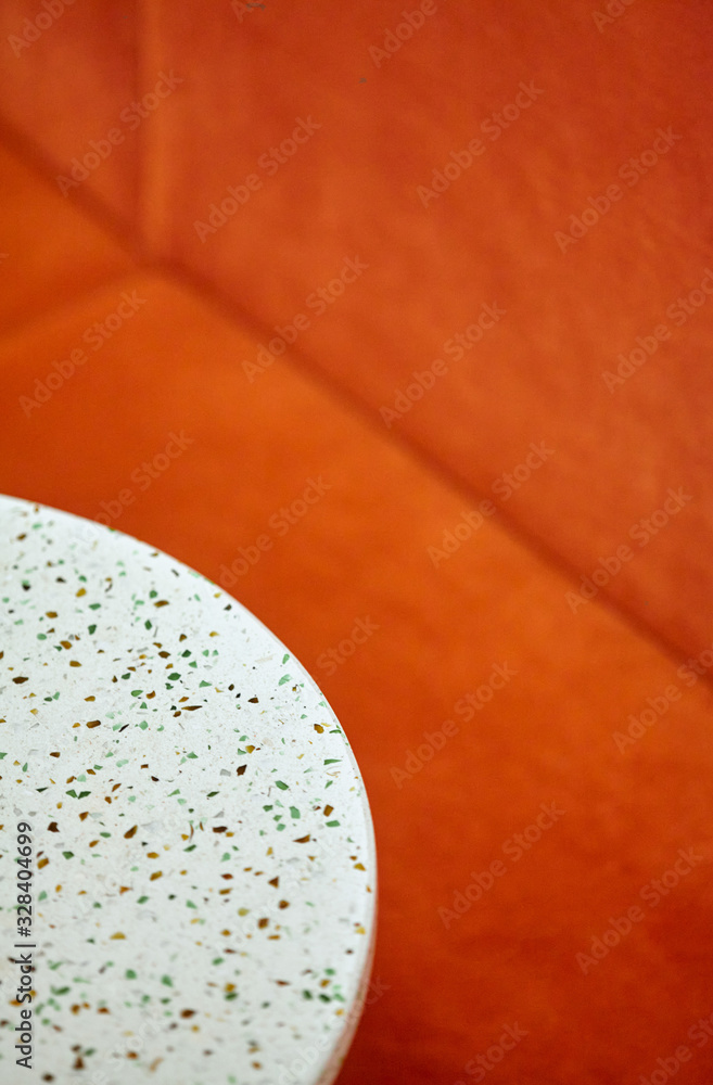 Obraz premium Closeup round white tables and orange sofa.Stylish.Background
