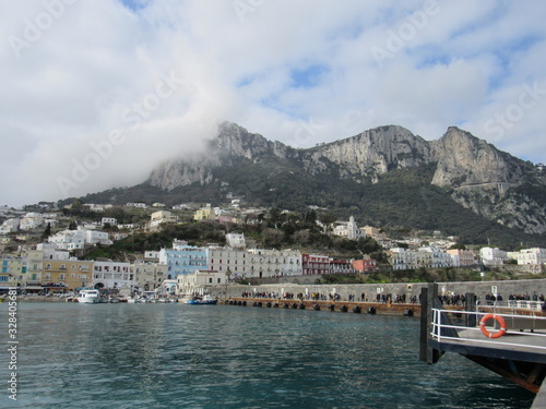 View of the coast and port of Capri, Italy on a sunny but cloudy day 