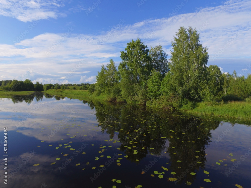 Obraz premium The old channel of the Vychegda river against a blue sky with clouds , Komi Republic, Russia
