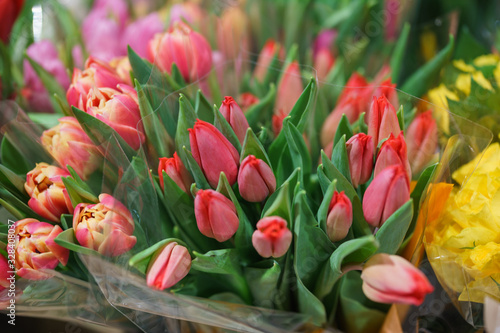 Bright fresh spring flowers tulips on the counter of a flower shop in the market. Beautiful gift for a girl or beloved woman. Soft focus and beautiful bokeh.