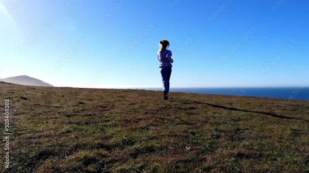 Slow motion effect of happy accomplished female tourist running to ocean bay for enjoying beautiful scenic view during summer vacations, excited hipster girl feeling great mood from achievement Slow motion effect of happy accomplished female tourist running to ocean bay for enjoying beautiful scenic view during summer vacations, excited hipster girl feeling great mood from achievement