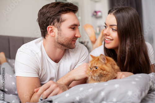 Happy sensual young couple lying in bed together.