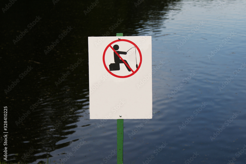 A sign prohibiting fishing in a lake or river. A sign prohibiting fishing in a lake or river.