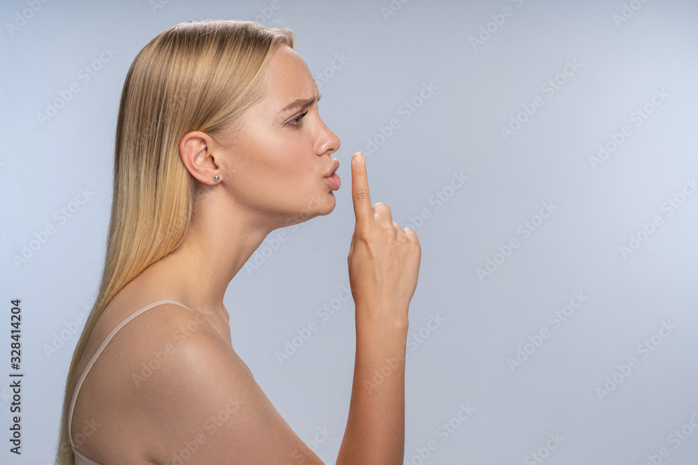 Girl holding a lifted index finger in front of her Girl holding a lifted index finger in front of her