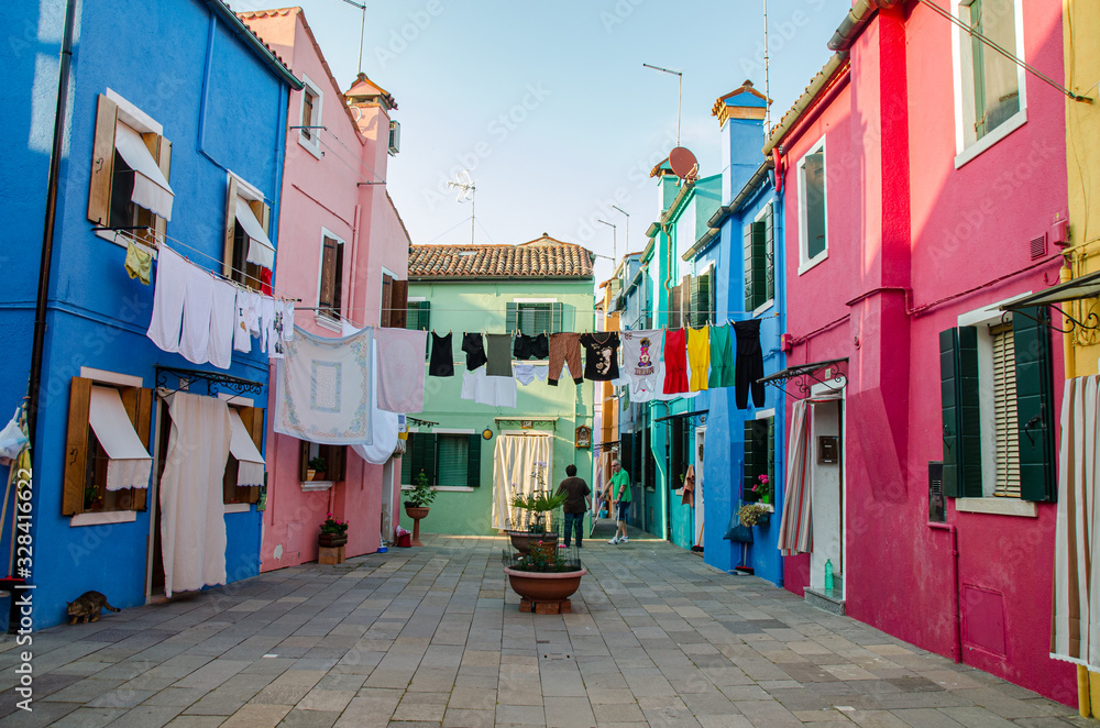 Obraz premium Venice, Italy May 18, 2015: Clothes hang dry with colorful houses alongside in Burano Italy
