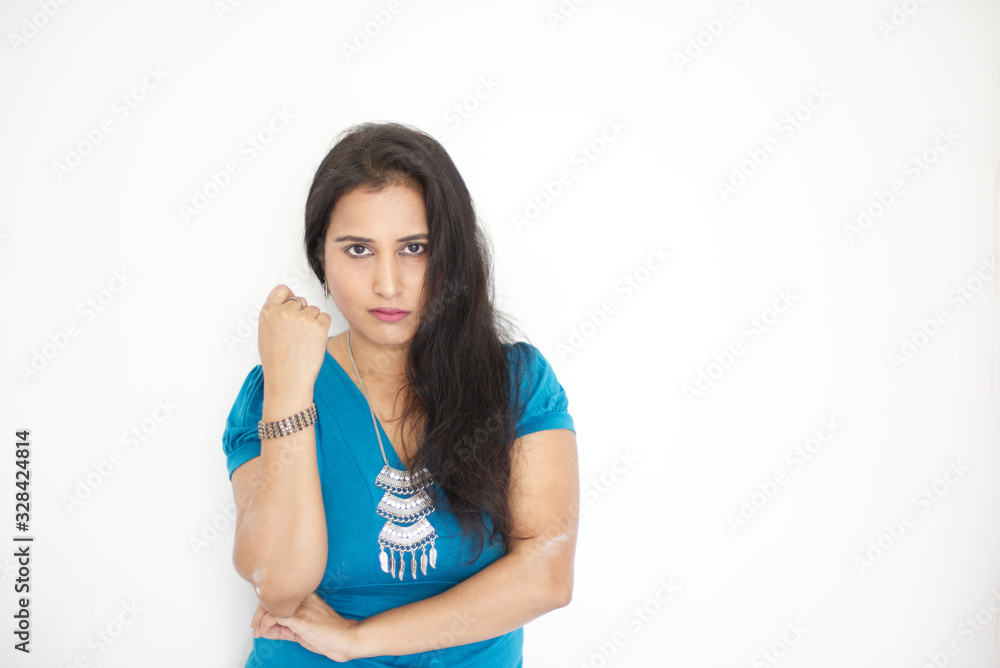 Prtrait of a beautiful Indian Bengali brunette woman wearing a blue top before a white copy space background. Indian lifestyle and fashion portrait Prtrait of a beautiful Indian Bengali brunette woman wearing a blue top before a white copy space background. Indian lifestyle and fashion portrait