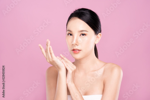 Beautiful Young Asian woman with clean fresh white skin touching hands softly in beauty pose. Girl smiling in isolated background. Facial treatment  cosmetic  make up and surgery advertisement
