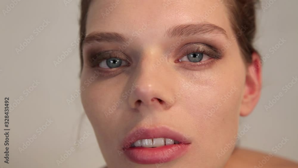 beautiful girl with blue eyes posing to the camera and showing her eye make up. close up. beautiful girl with blue eyes posing to the camera and showing her eye make up. close up.
