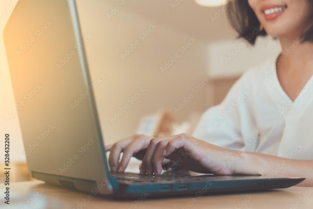 Fototapeta premium Happy woman smile while using laptop to work study on work desk with clean nature background background. Business, financial, trade stock maket and social network.