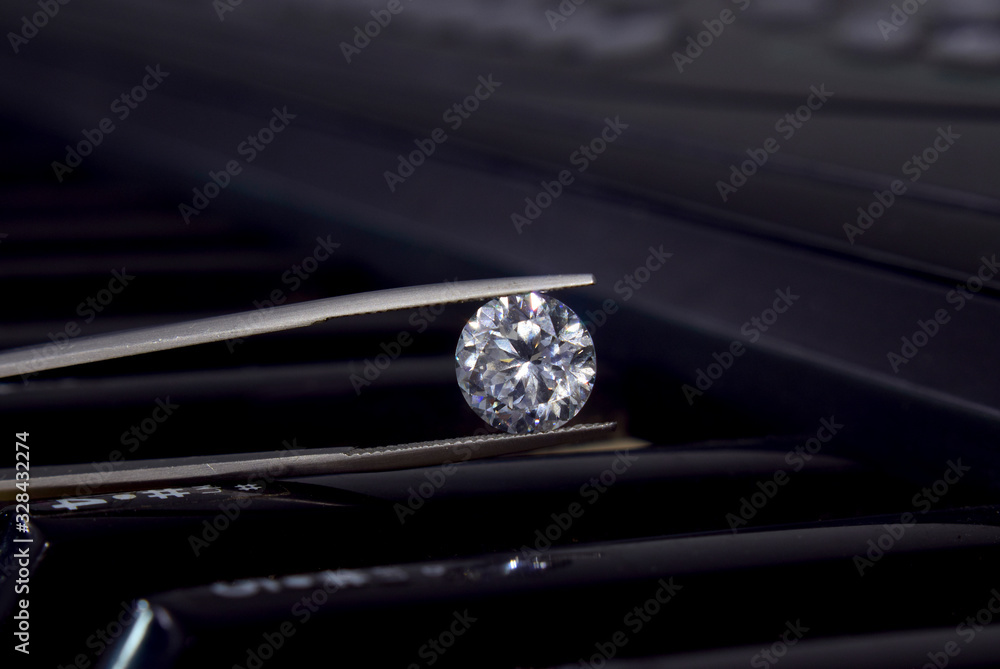 Selected diamonds In the tong On the piano background Selected diamonds In the tong On the piano background