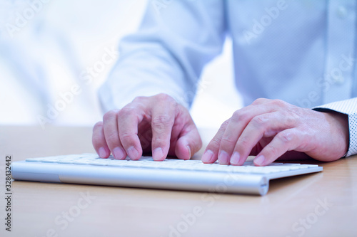 Billede på lærred Close-up of a man or author’s hands on home keys while touch-typing on a modern white computer keyboard in action of data input or writing article