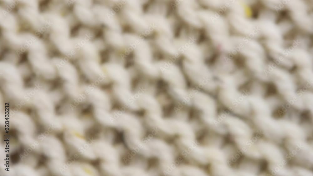 Fibers of knitted clothes with beige color threads. Knitted fabric threads macro. Fibers of knitted clothes with beige color threads. Knitted fabric threads macro.