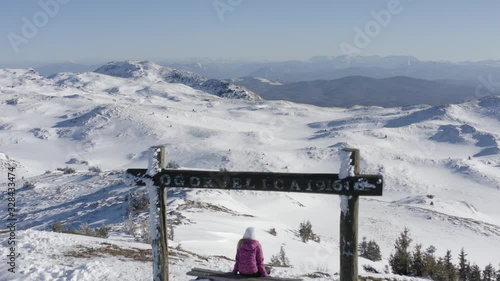 Young woman sitting and watching beautiful mountain landscape in Jahorina mountain ski Olympic center. National park in Bosnia and Hezegovina.
Drone flyover young model filmed in 4k photo