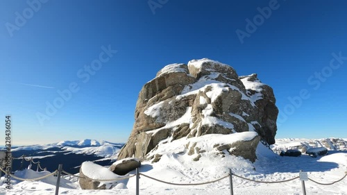 Hyper lapse shot around the sphinx rock formation, sunny, winter day, in the Bucegi Natural Park, southern Carpathians, Romania photo