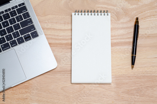 Laptop computer and stationary on the wooden background