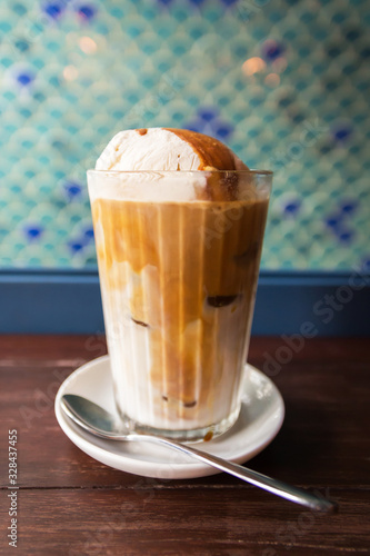Ice latte coffee with scoop of vanilla ice cream and caramel syrup on top