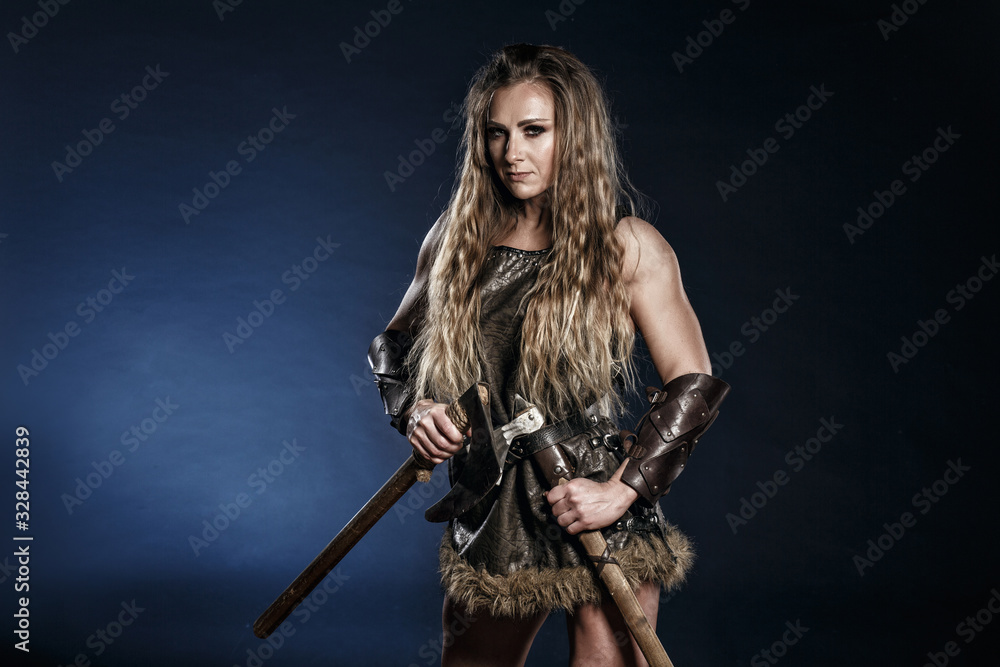 Beautiful female viking woman warrior in battle with big two-handed sword. Ancient times. Amazon fantasy blonde hair sexy girl. Beautiful female viking woman warrior in battle with big two-handed sword. Ancient times. Amazon fantasy blonde hair sexy girl.