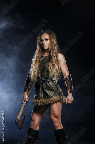 Beautiful female viking woman warrior in battle with big two-handed sword. Ancient times. Amazon fantasy blonde hair sexy girl.