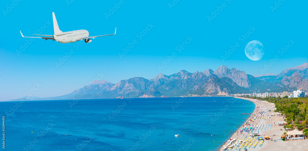 Fototapeta premium White an air plane fly over the konyaalti beach and blue sea - Antalya, Turkey