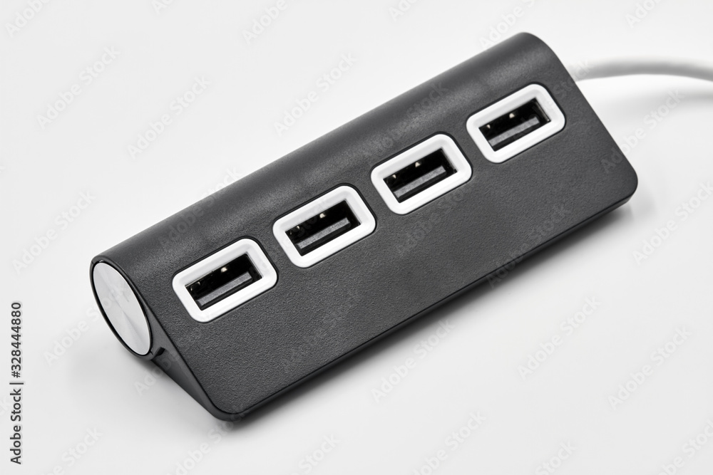 Black portable USB hub for four connections on a white background. Bus povered. Closeup, selective focus Black portable USB hub for four connections on a white background. Bus povered. Closeup, selective focus