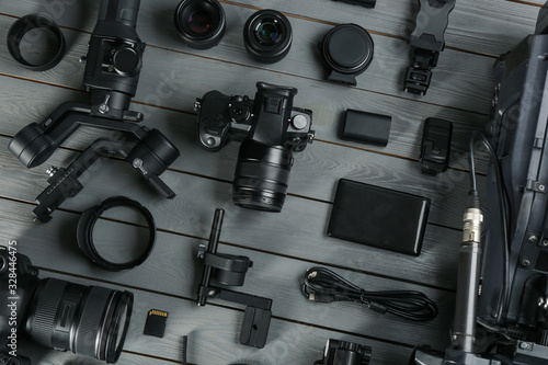 Flat lay composition with video camera and other equipment on grey wooden table