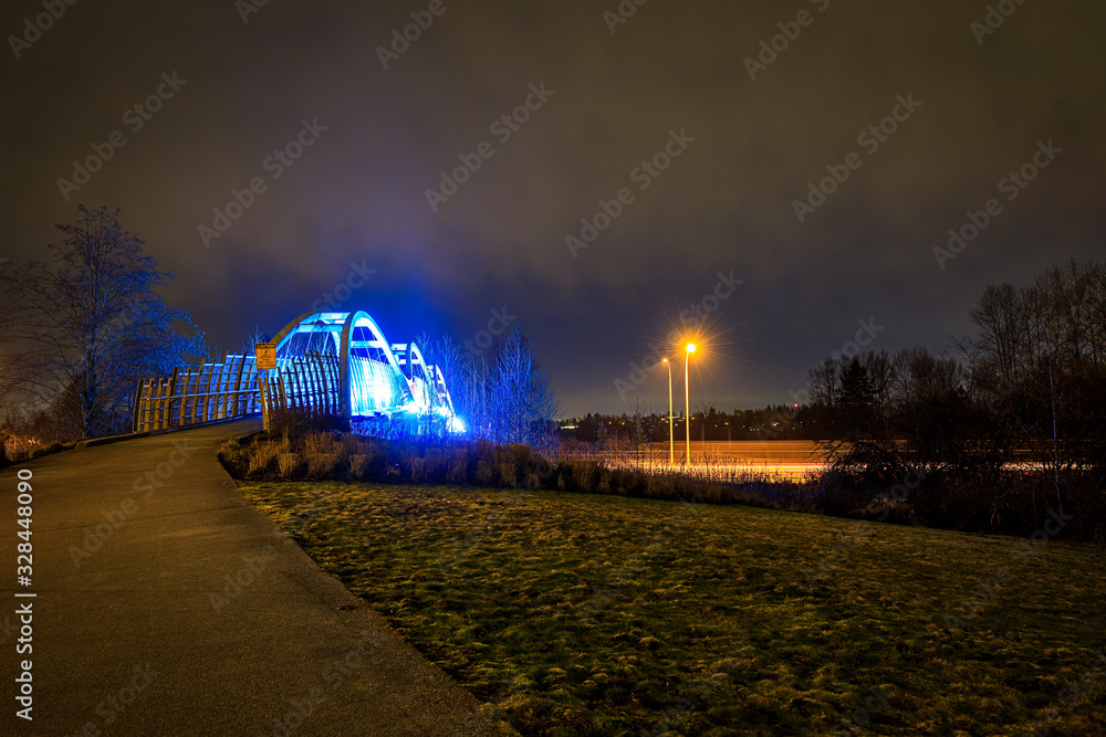 Pedestrian overpass lit up in bright blue LEDs at night