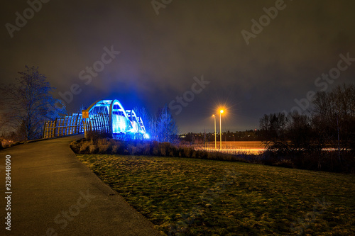 Obraz na płótnie Pedestrian overpass lit up in bright blue LEDs at night w salonie