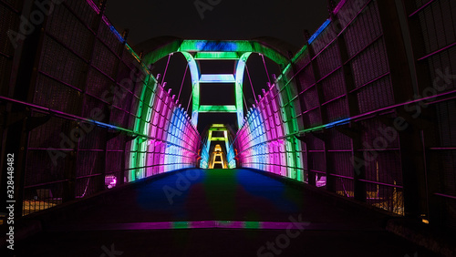 Obraz na płótnie Bright colors illuminate pedestrian walkway over highway at night w salonie