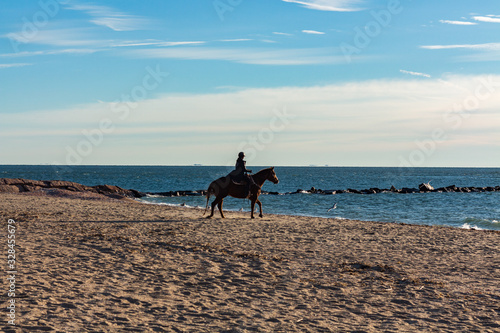 Girl on horse ridding on the beach