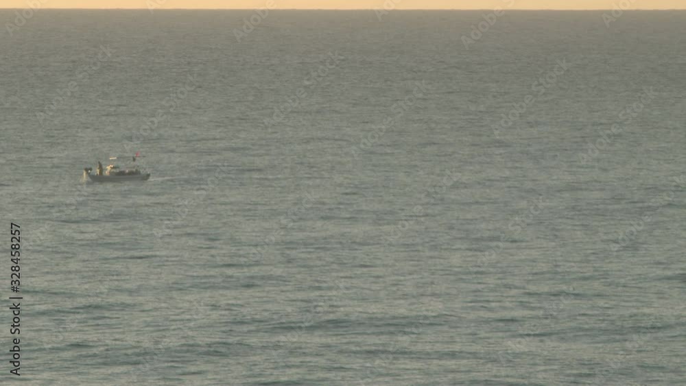 A lone fisherman works from his fishing trawler at sunrise A lone fisherman works from his fishing trawler at sunrise