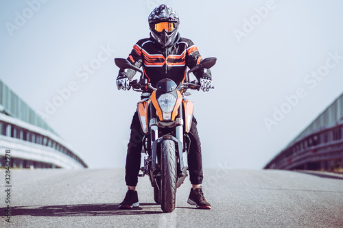 Motor biker ready to go on an empty road. Outdoors adventures and freedom concept.Motorcycle trip. Start or restart concept