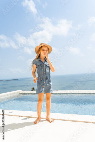 Little girl with red hair shows different emotions. Sadness, joy and happiness. She smiles and cries. In jeans with skin pigment on his face, freckles overlooking the sea. FASHIONABLE CHILD © Underwater girls