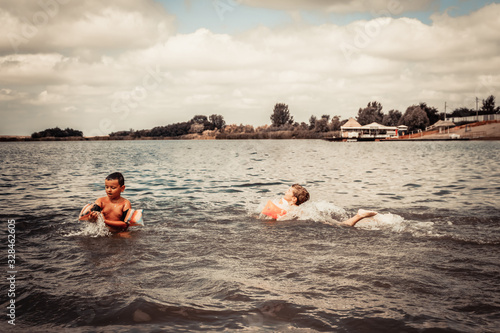 Small boys swimming in the water in summer day.
