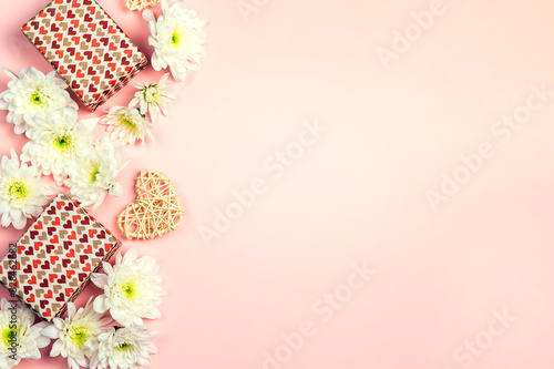 Gifts with chrysanthemums and heart on a pink background. © WindyNight