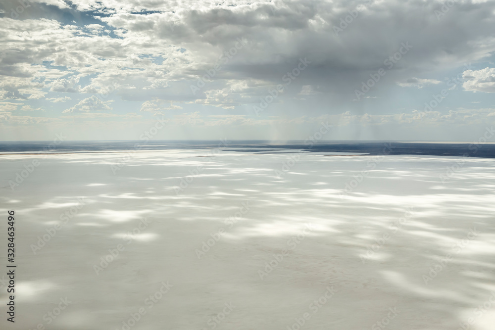 Kati Thanda-Lake Eyre Salt Flats outback South Australia aerial photography with rainfall backdrop and dramatic clouds casting shadows on the white salt lake, Australia