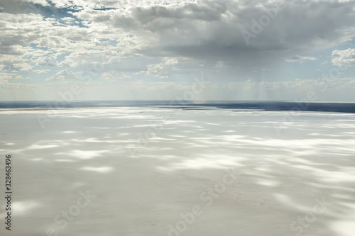 Kati Thanda-Lake Eyre Salt Flats outback South Australia aerial photography with rainfall backdrop and dramatic clouds casting shadows on the white salt lake, Australia