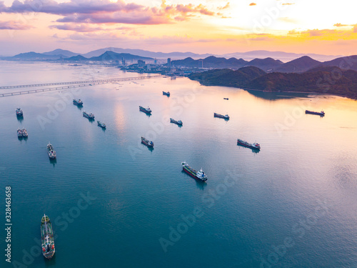 Aerial view from drone, Oil tanker ships off the coast in beautiful light sundown, professional business logistics and transportation of energy fuels.