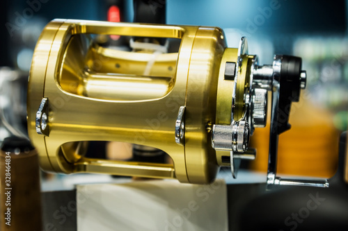 large size fishing multiplier reel on the counter in a fishing store. Shallow depth of field