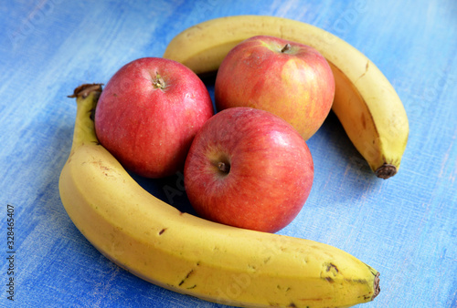 apples and bananas on wooden background