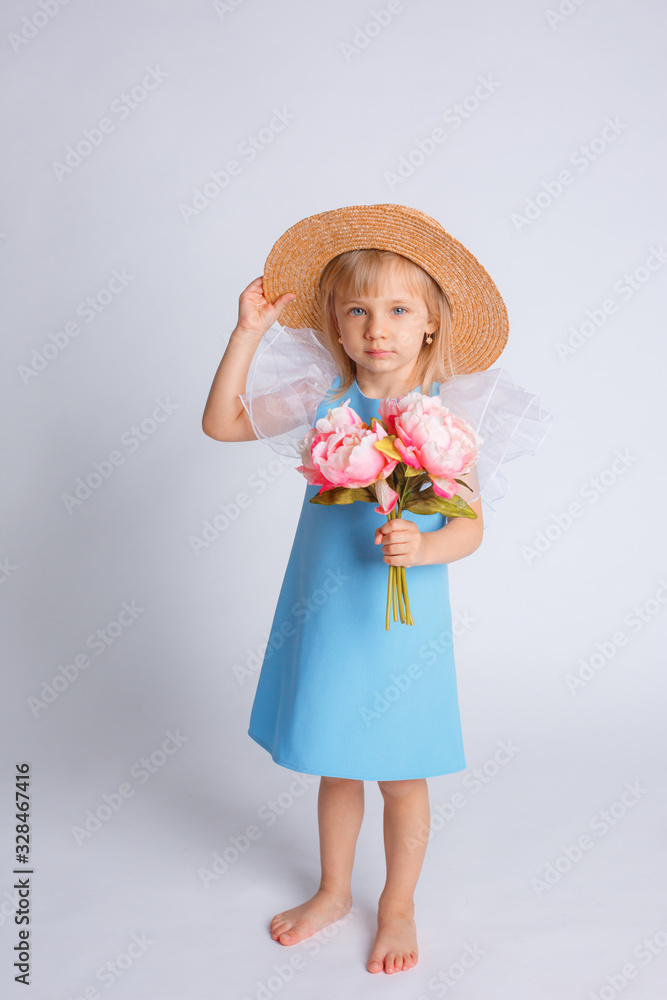 baby girl with a bouquet of flowers and a straw hat on a white background baby girl with a bouquet of flowers and a straw hat on a white background