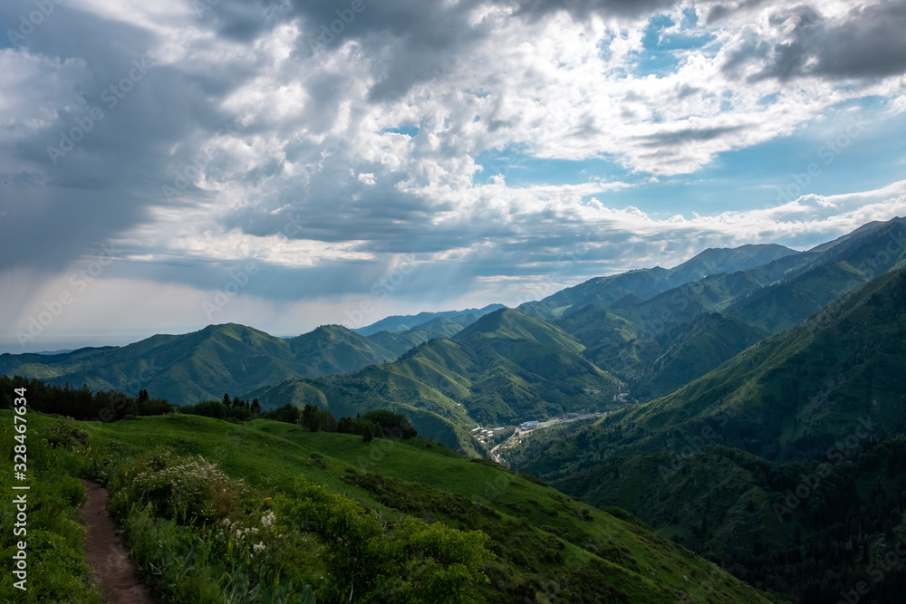 Almaty mountains with cloudy stormy clouds. Overcast - weather storm. Rain in mountains.