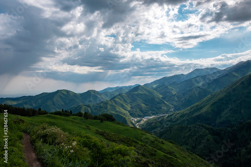 Almaty mountains with cloudy stormy clouds. Overcast - weather storm. Rain in mountains.