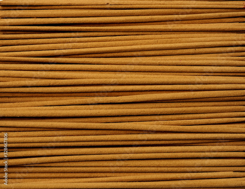Close up of incense sticks showing brown powder in horizontal direction.