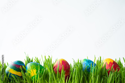 Easter eggs in green grass on a white background