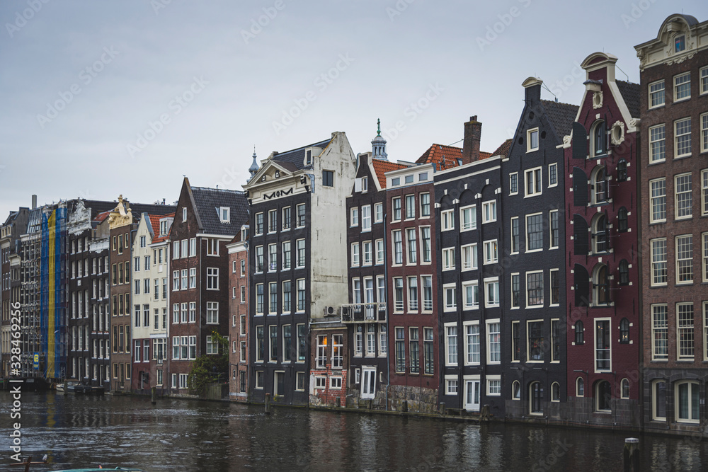 nice colored houses, thin and tall. They are old and are built in front of the canal