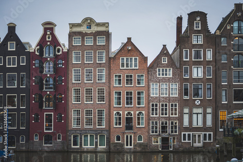 nice colored houses, thin and tall. They are old and are built in front of the canal