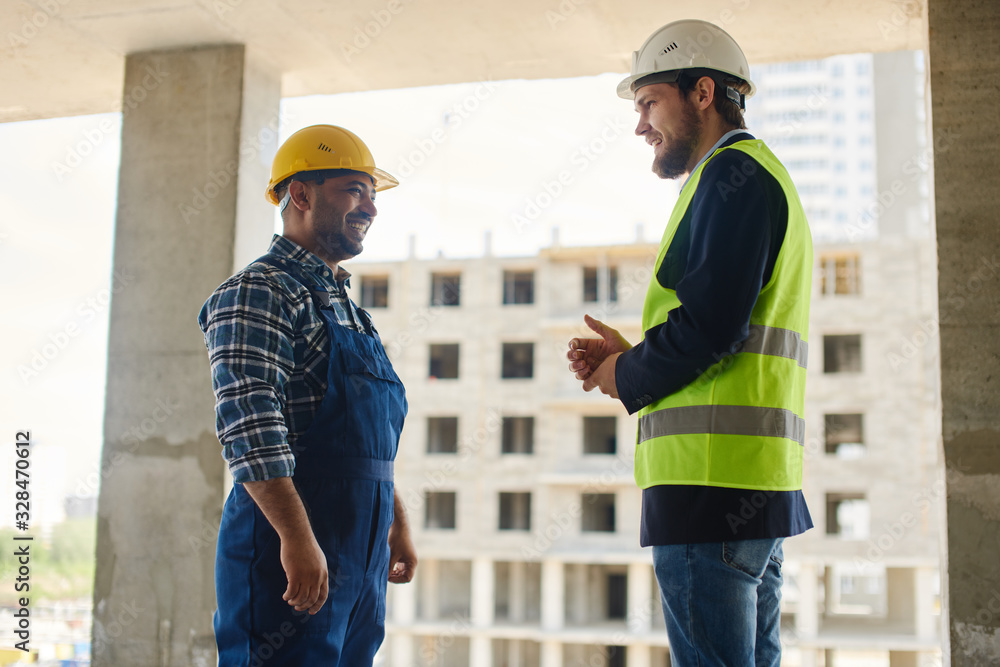 Two engineers discuss work related questions together. Two engineers discuss work related questions together.
